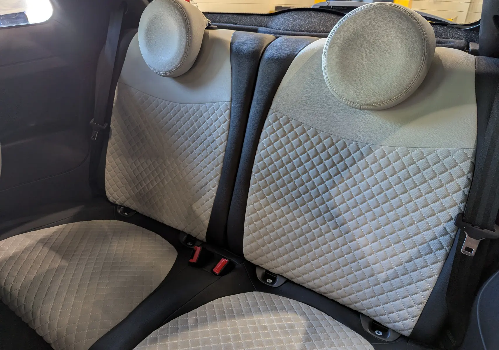 Gros plan sur les sièges arrière en cuir beige matelassé de la Fiat 500 1.0 70 CH Hybride DolceVita 2021.