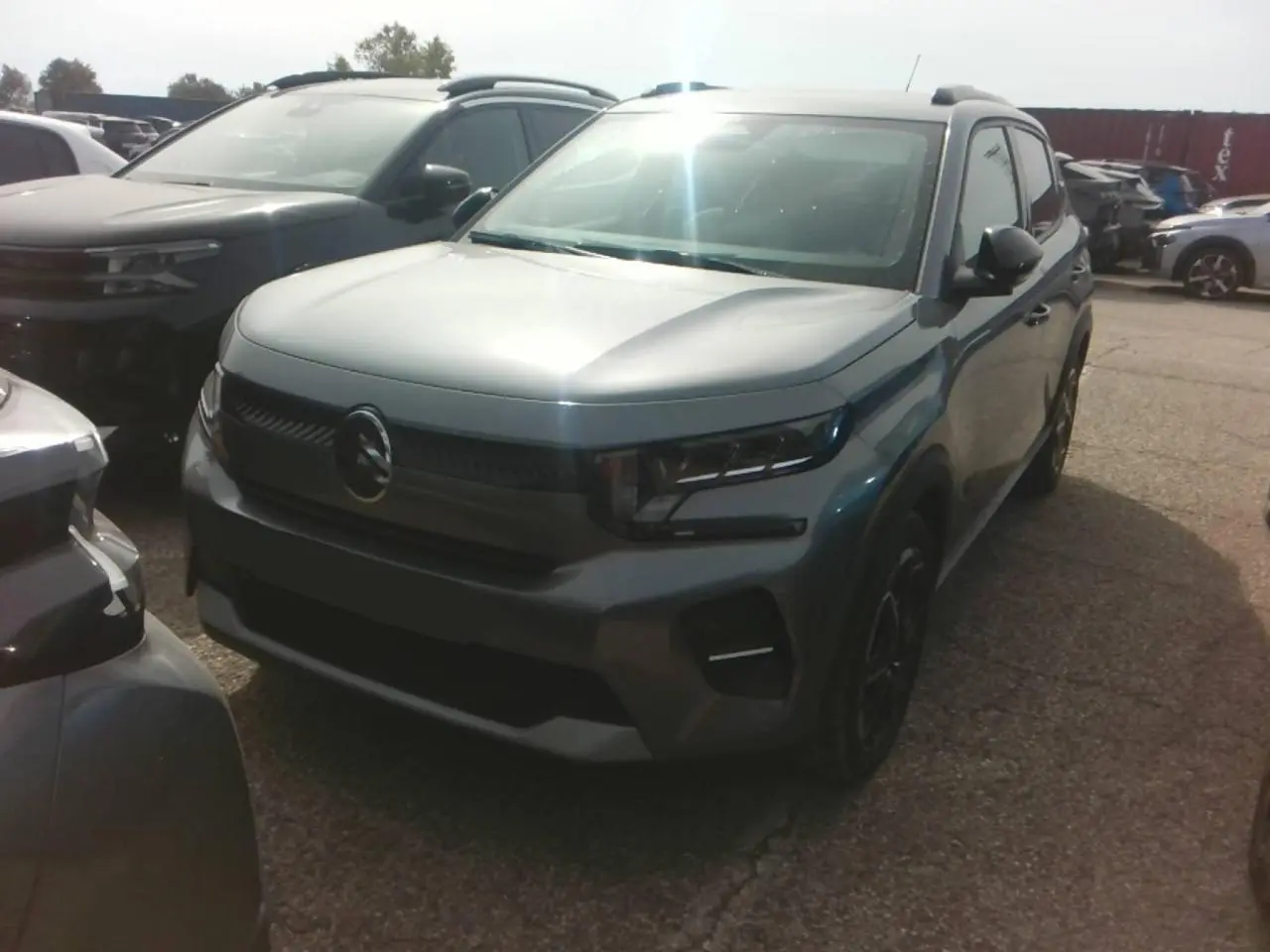 Citroën C3 Turbo 100 Max gris Mercury vue 3/4 avant droit, avec barres de toit noir brillant et jantes alliage.