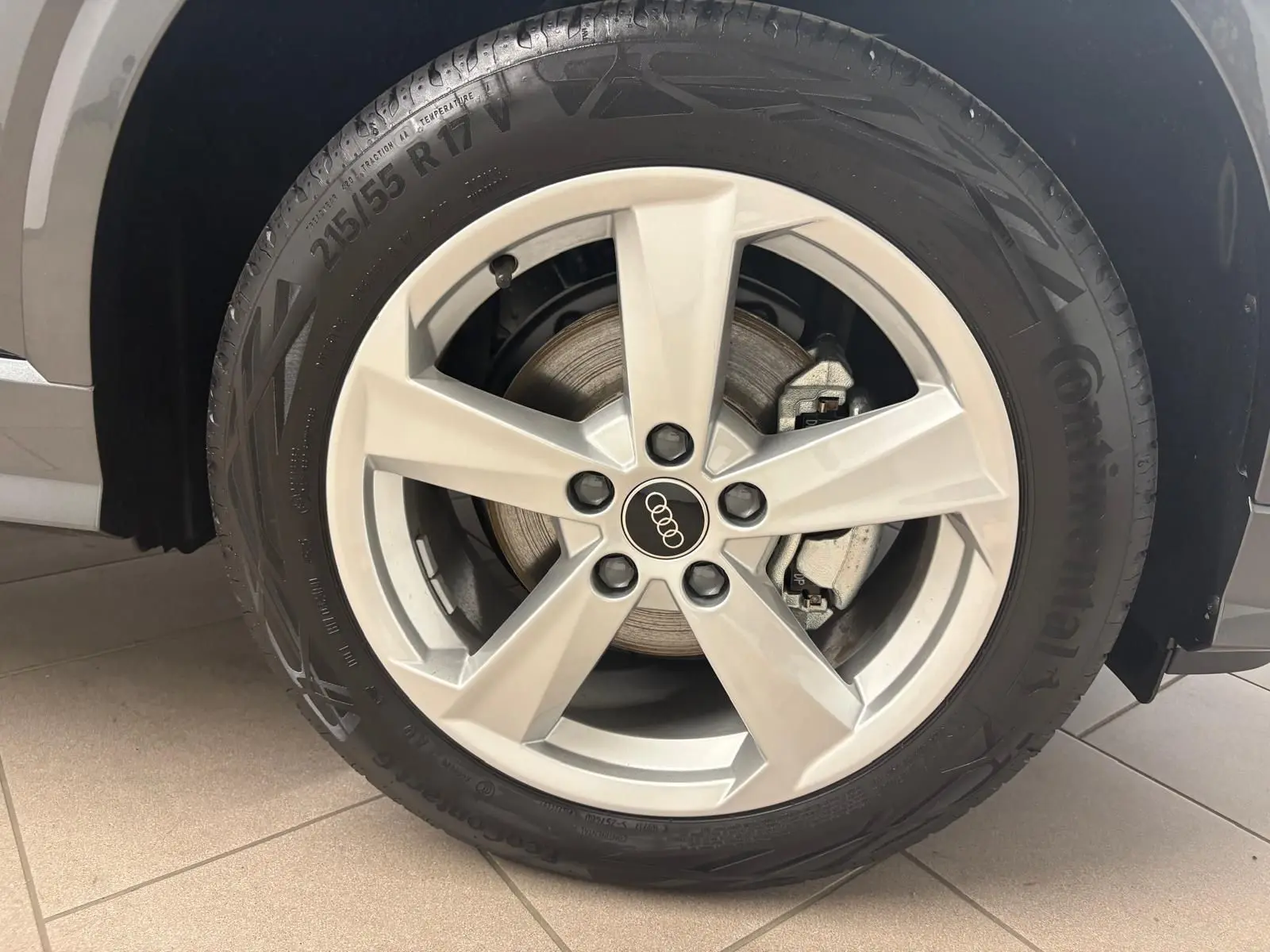 Gros plan sur la roue avant gauche de l'Audi Q2 35 TFSI 150 S Line gris Daytona avec jante alliage cinq branches.