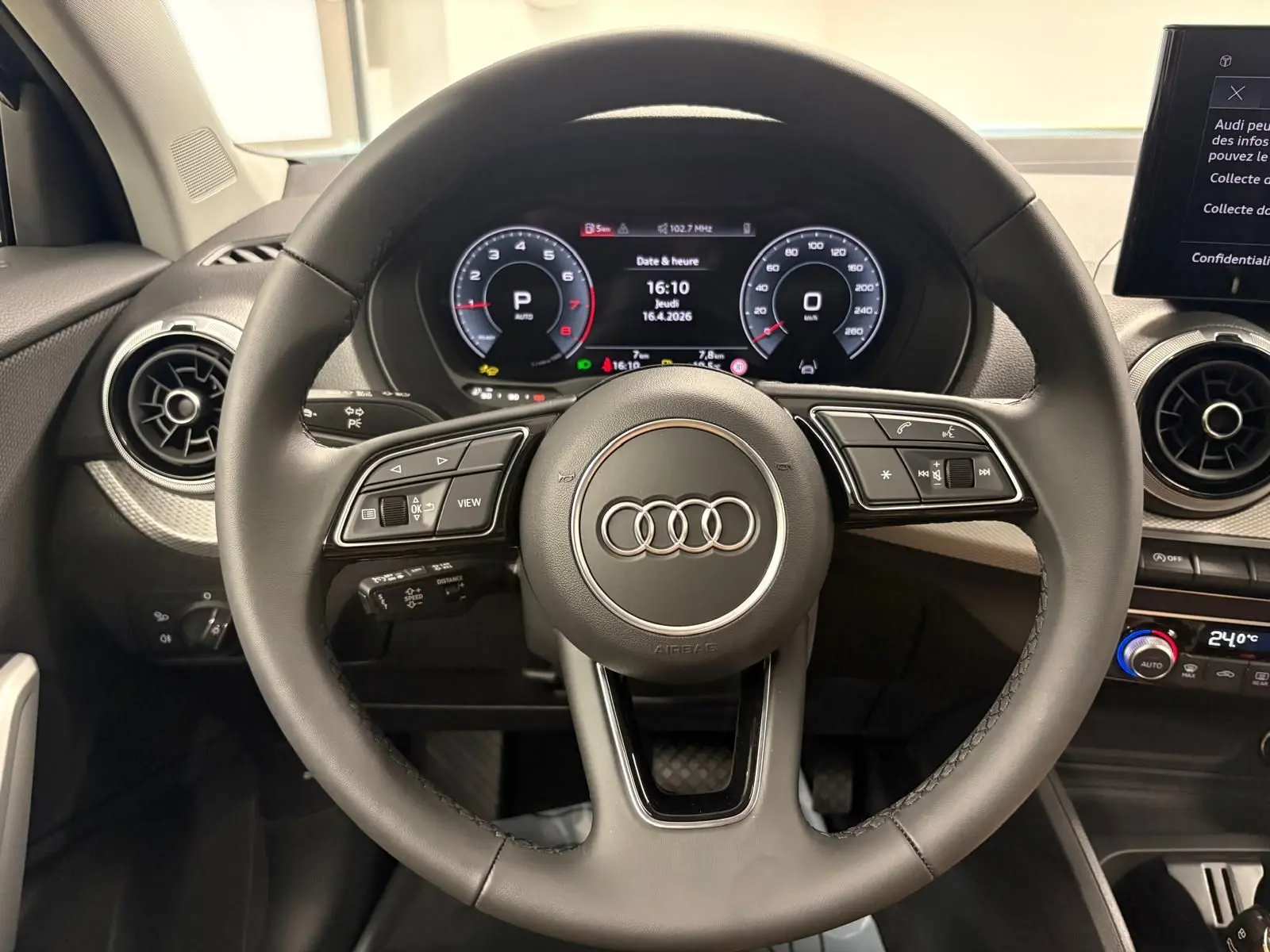 Vue rapprochée du volant et du tableau de bord numérique de l'Audi Q2 35 TFSI S Line, intérieur noir.