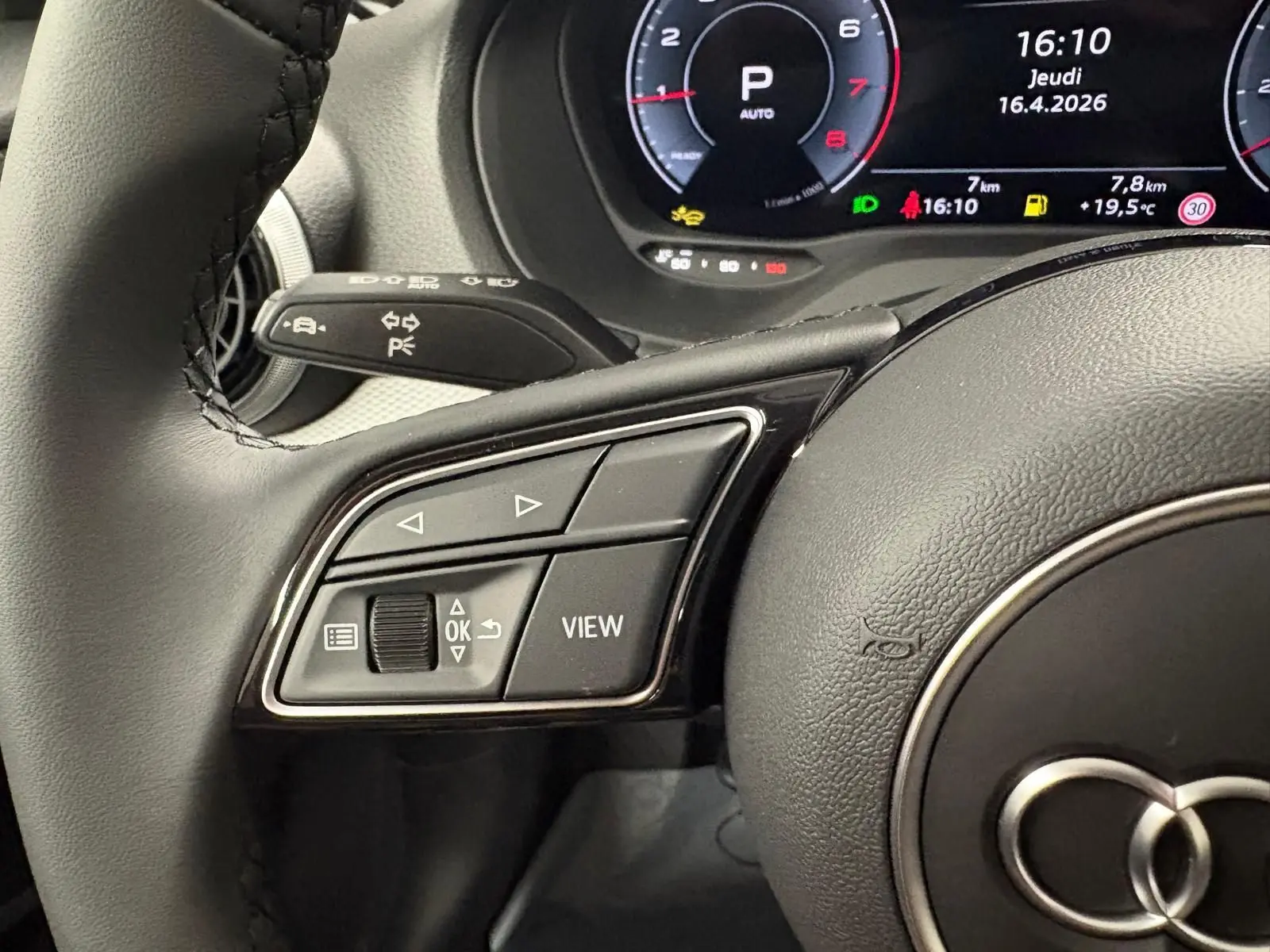 Gros plan sur les commandes au volant à gauche de l'Audi Q2 35 TFSI 150 S Line 2026 avec tableau de bord numérique.