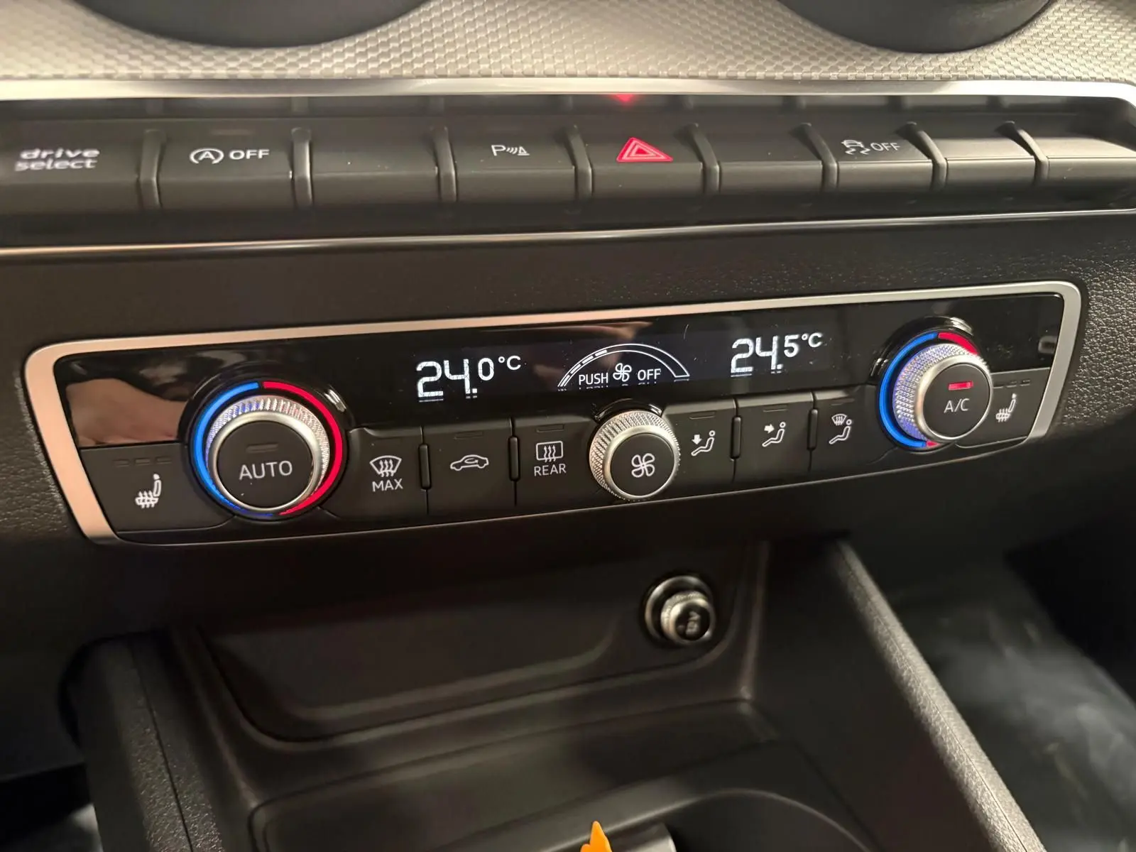 Vue rapprochée du tableau de bord de l'Audi Q2 35 TFSI S Line 2026, montrant la climatisation automatique et les réglages de température.