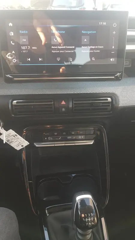 Intérieur de la Citroën C3 2024 montrant la console centrale avec écran tactile, climatisation automatique et levier de vitesses manuel.