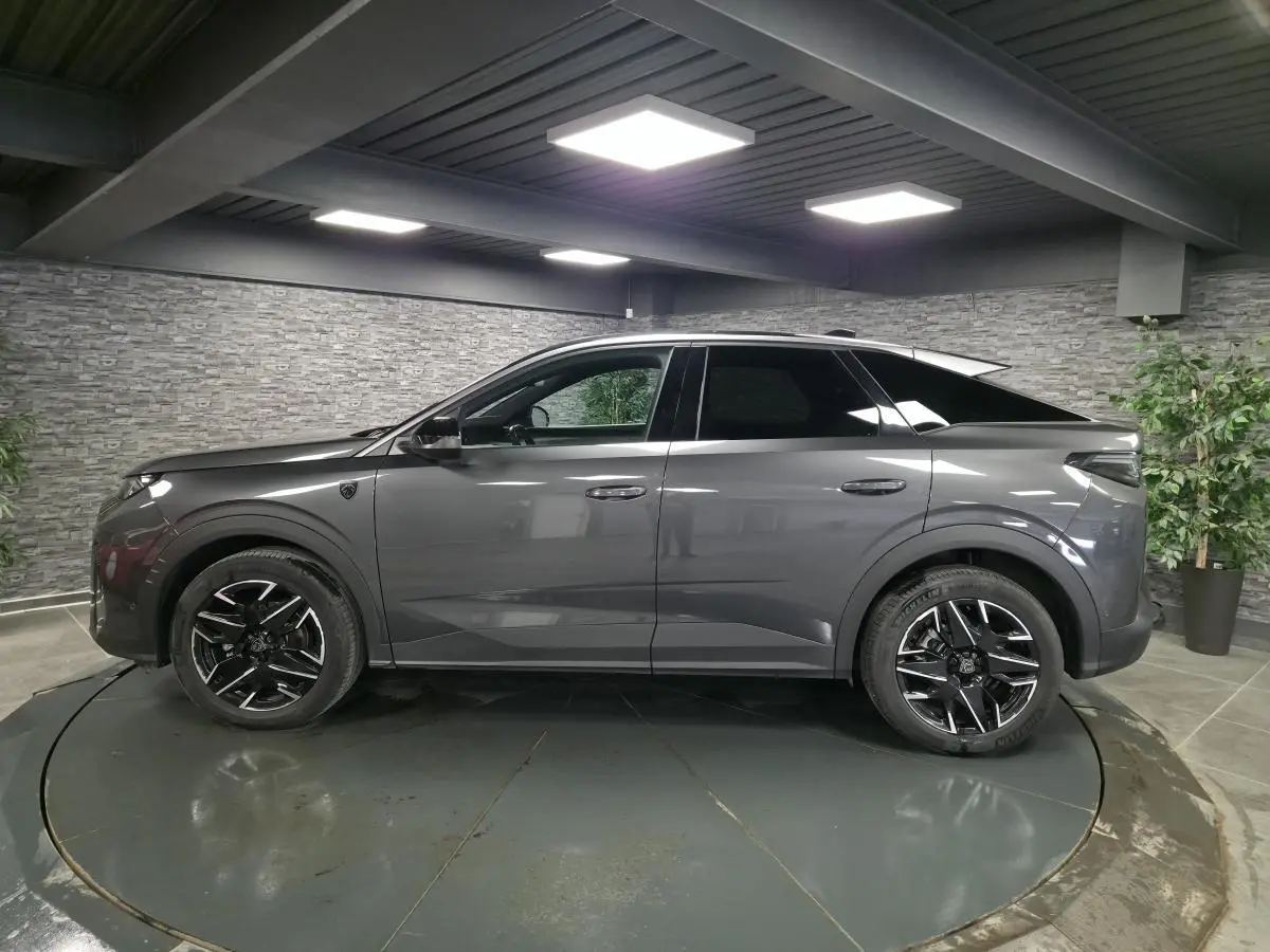 Peugeot 3008 gris métallisé vue de profil côté gauche, avec jantes alliage noires et toit noir contrasté.