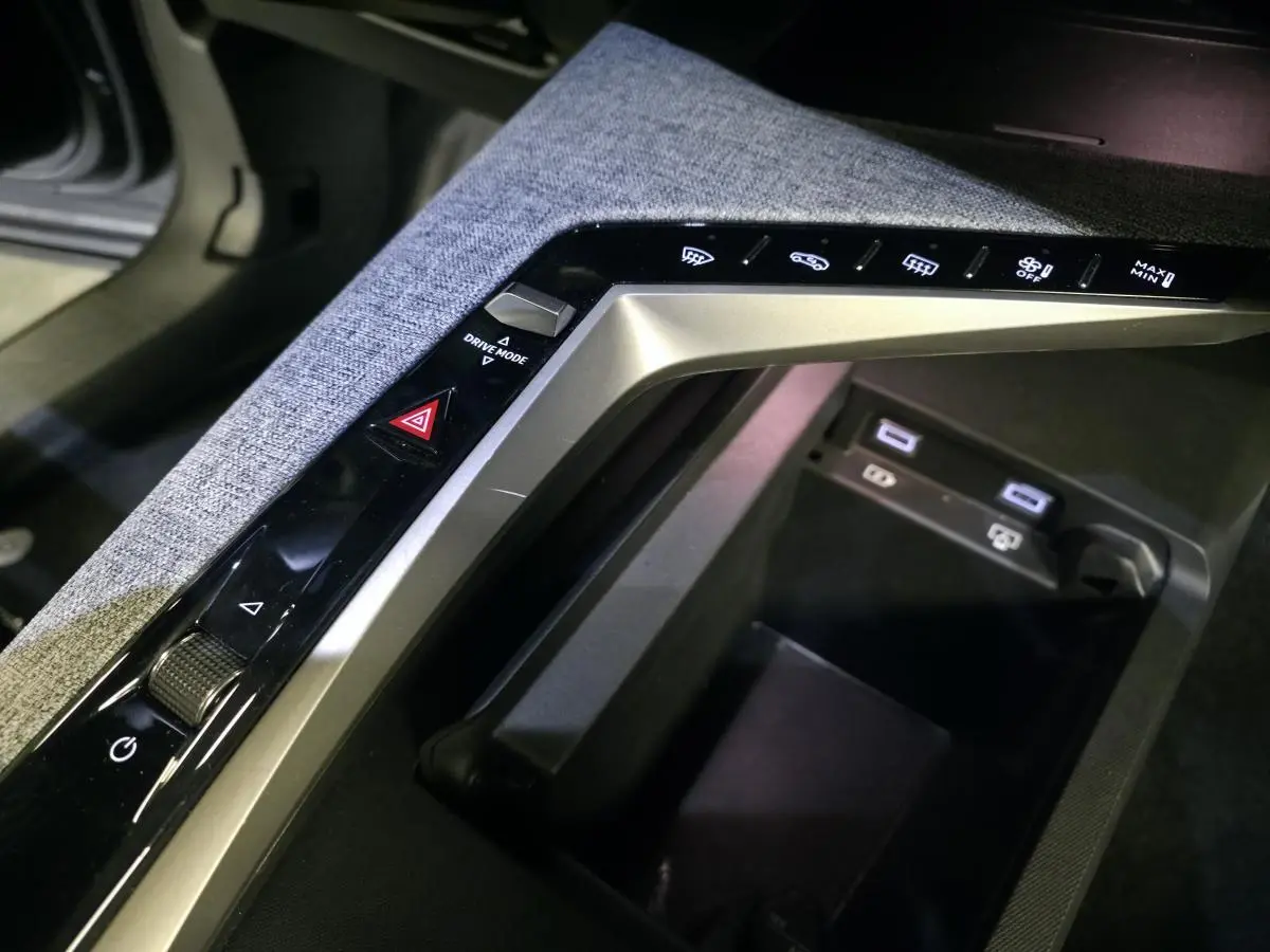 Gros plan sur la console centrale grise chinée du Peugeot 3008 2025 avec commandes tactiles et ports USB-C.