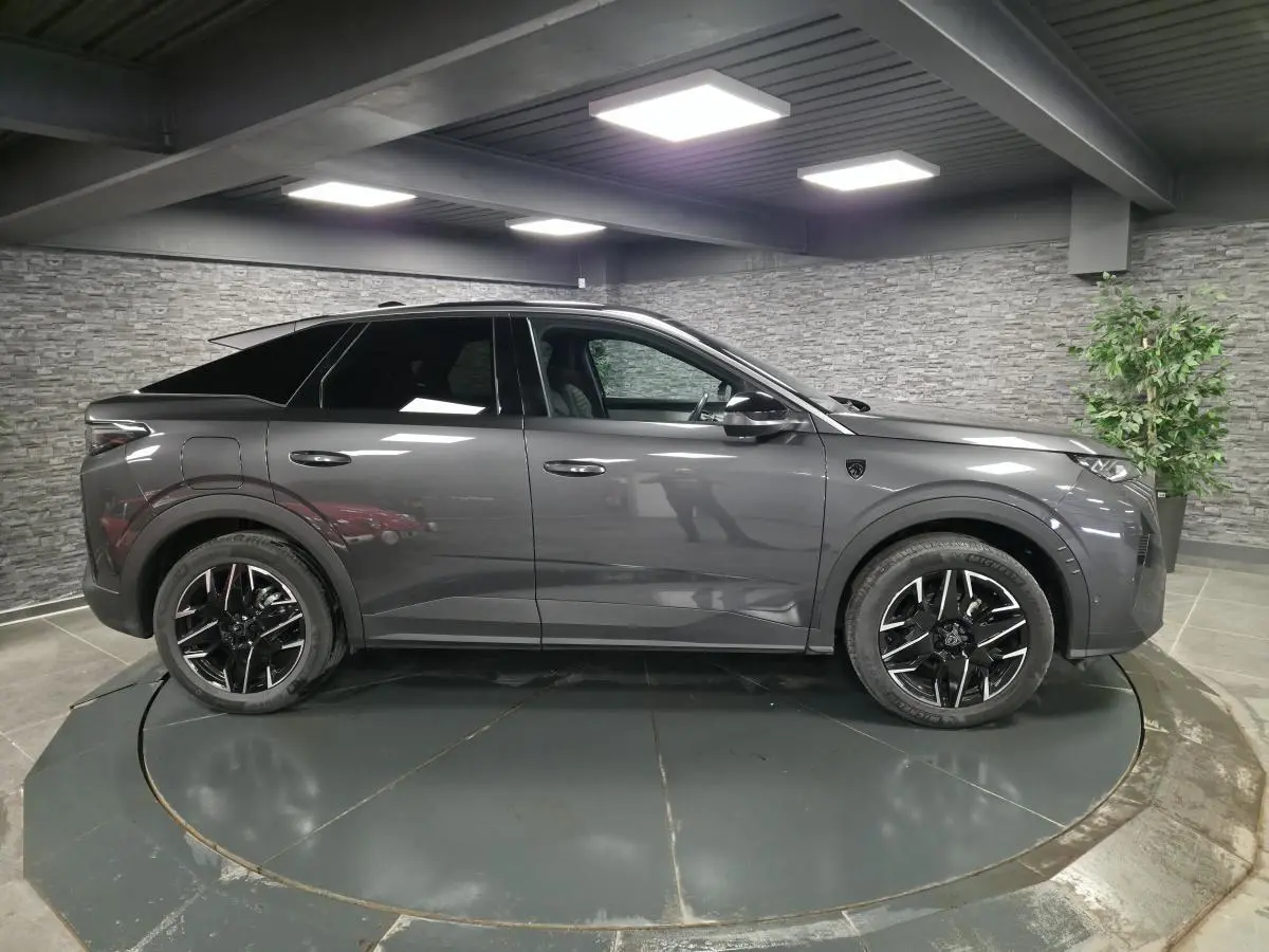 Vue de profil côté gauche du Peugeot 3008 gris 2025 avec toit noir et jantes alliage noires diamantées.
