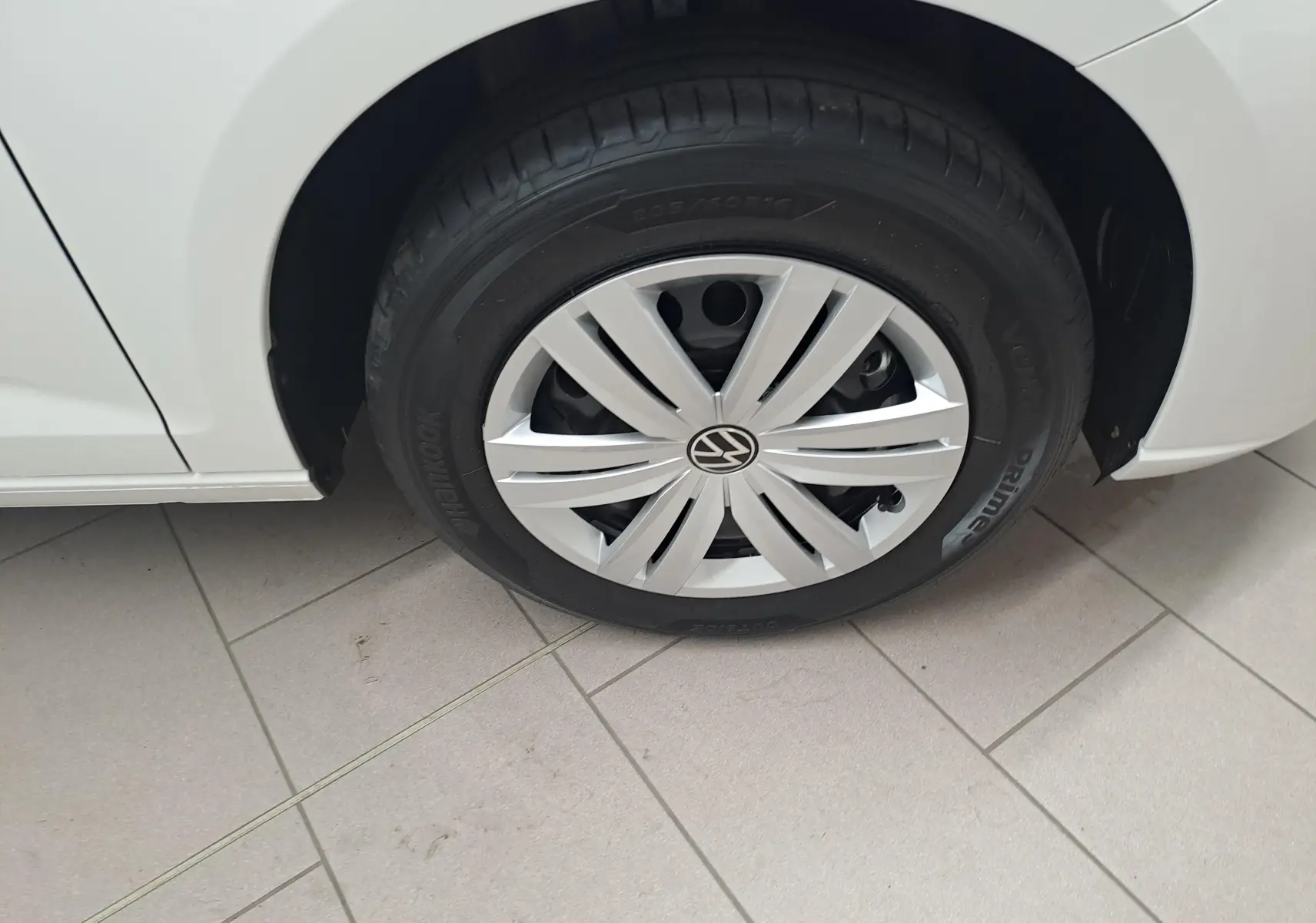 Gros plan sur la roue avant gauche blanche candy du Volkswagen Caddy Cargo Maxi 2026 avec enjoliveur et pneu Hankook.