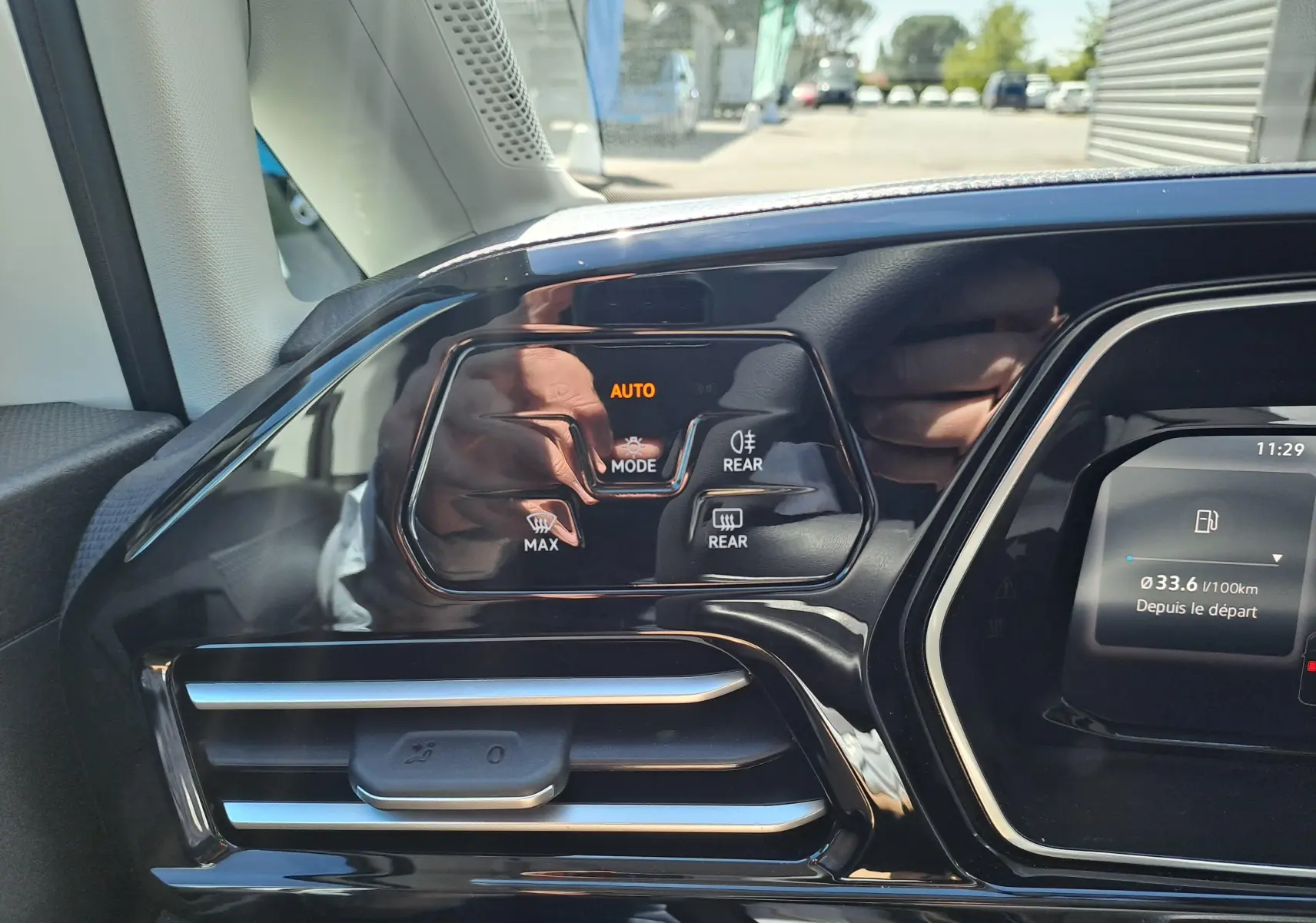 Détail du tableau de bord noir brillant côté gauche du Volkswagen Caddy Cargo Maxi 2026 avec commandes climatisation et écran partiel.