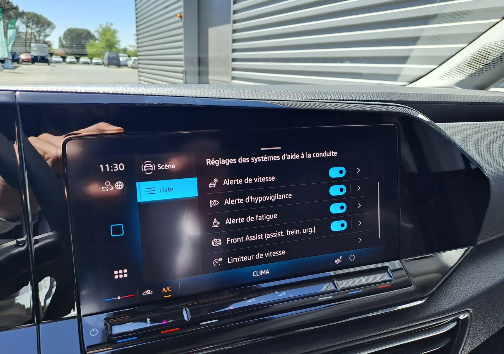 Vue intérieure du tableau de bord du Volkswagen Caddy Cargo Maxi blanc, avec écran tactile affichant les aides à la conduite.
