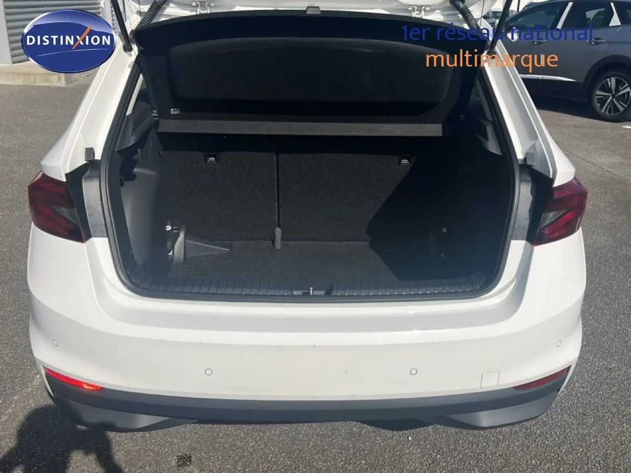 Vue arrière d'une Skoda Fabia blanche Candy 2022 avec coffre ouvert, montrant l'espace de chargement vide.