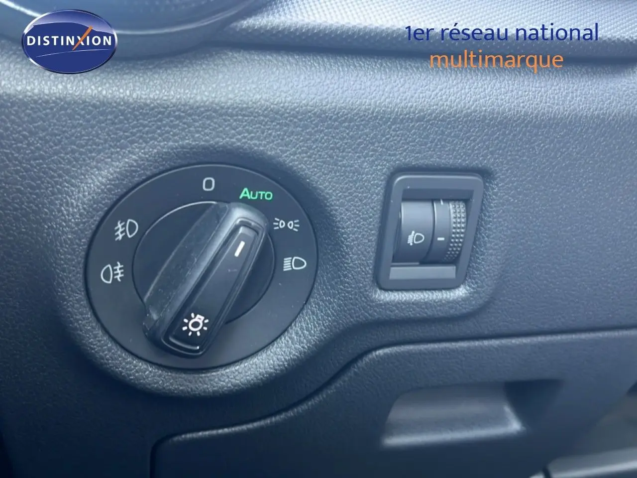 Gros plan sur la molette de réglage des phares dans l'habitacle d'une Skoda Fabia blanche 2022.