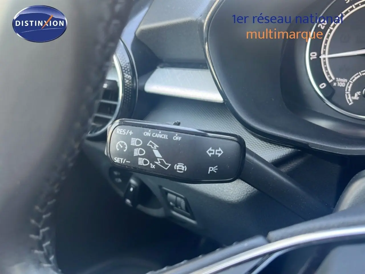 Gros plan sur la commande de régulateur de vitesse à gauche du volant dans l’habitacle d’une Skoda Fabia blanche.