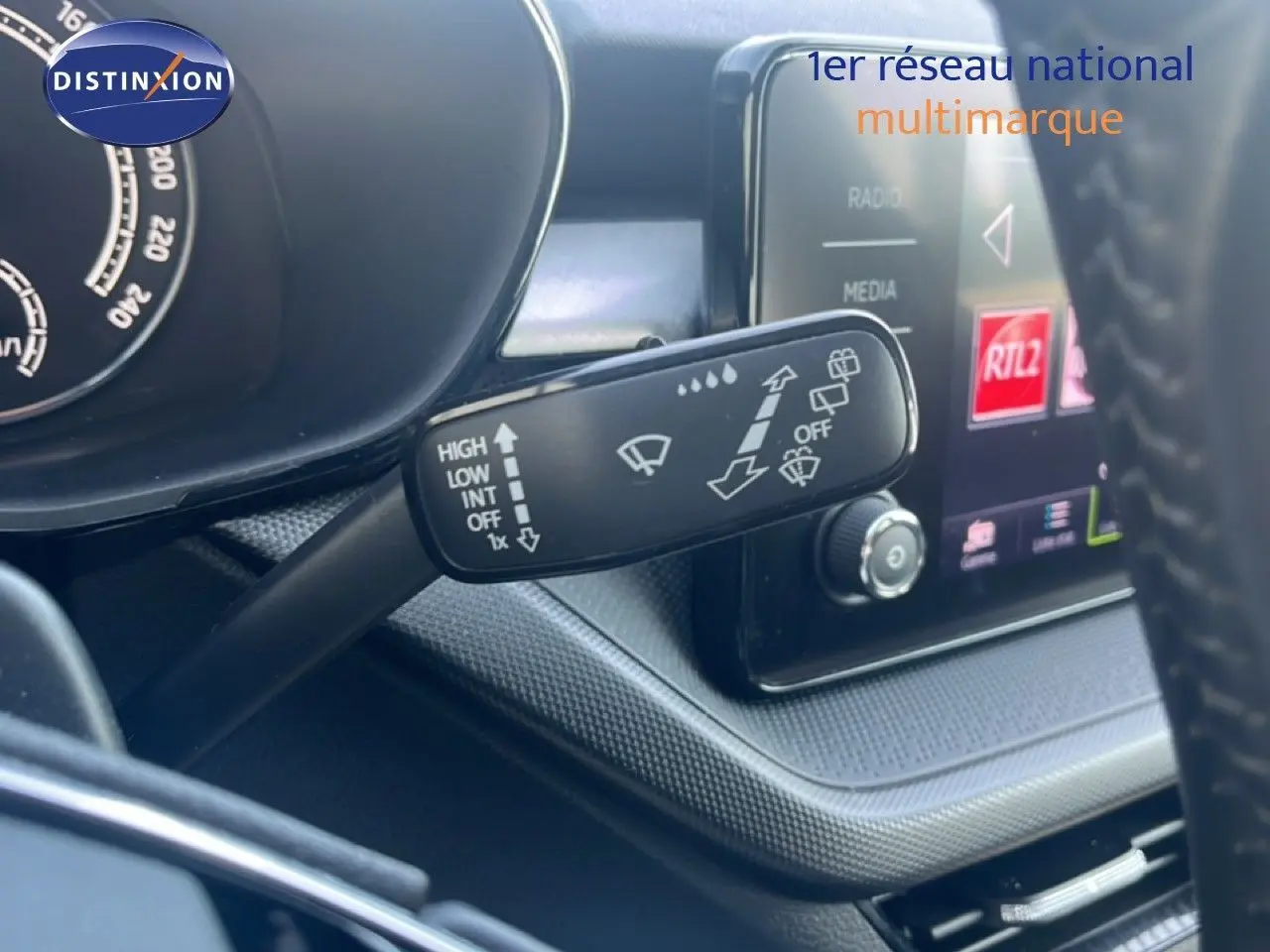 Gros plan sur la commande d’essuie-glace à gauche du volant dans l’habitacle d’une Skoda Fabia blanc candy 2022.
