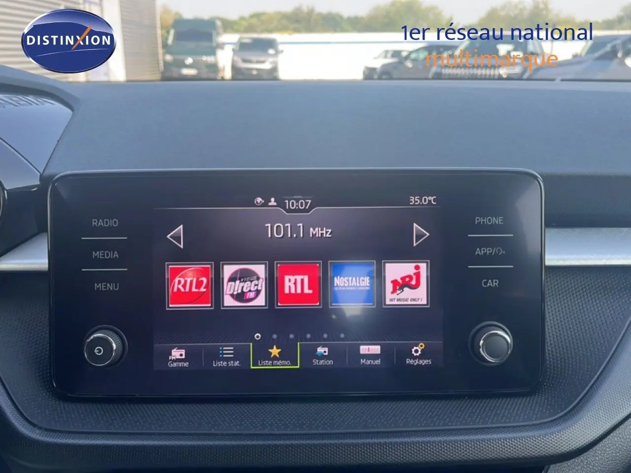 Vue rapprochée de l’écran multimédia central d’une Skoda Fabia blanche, affichant des stations radio.