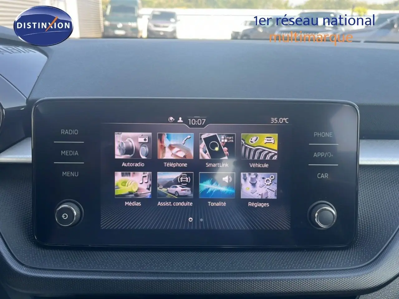 Écran tactile central de la Skoda Fabia blanche, vue de face sur le tableau de bord avec interface multimédia affichée.