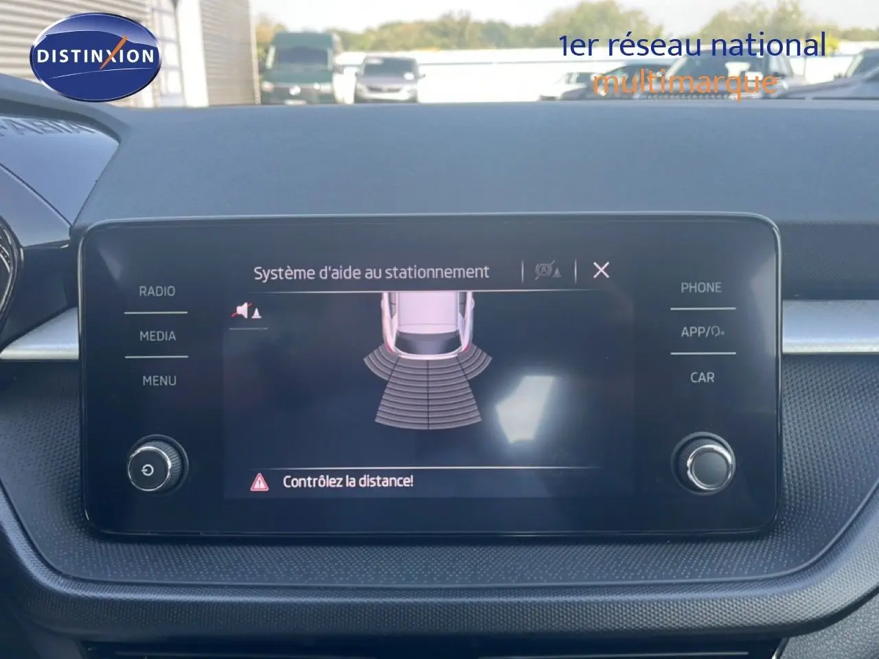 Écran central du système d'aide au stationnement dans une Skoda Fabia blanche, vue intérieure du tableau de bord.
