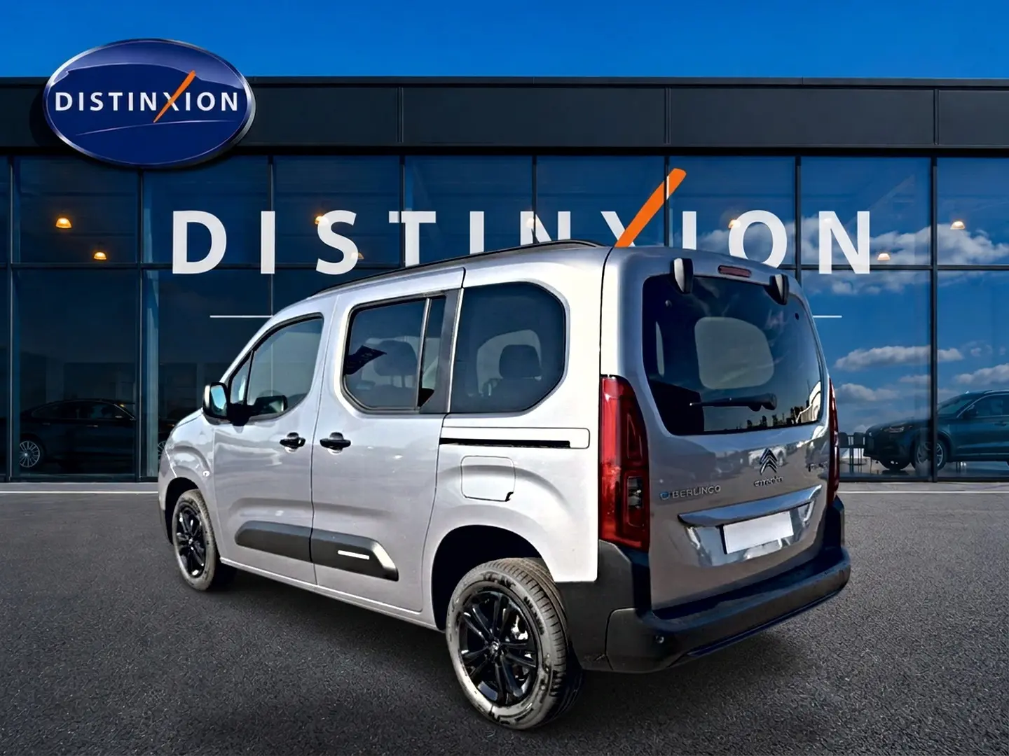 Vue 3/4 arrière droite du Citroën Berlingo Steel Grey avec jantes alu noires et barres de toit visibles.