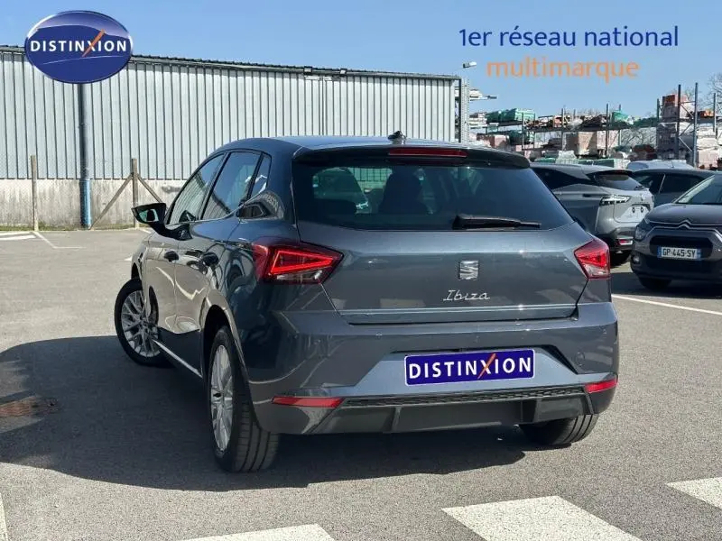SEAT Ibiza 2025 gris magnétique métallisé vue 3/4 arrière droit, feux arrière LED et logo distinctif visibles.