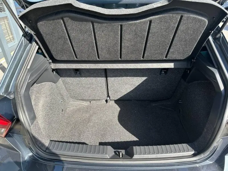 Coffre ouvert vu de l'arrière d'une SEAT Ibiza 2025 gris magnétique métallisé, montrant l'espace de chargement vide.