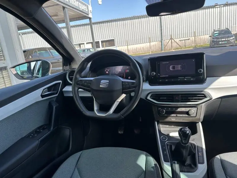 Vue intérieure avant du poste de conduite de la SEAT Ibiza 2025, avec volant multifonction et écran tactile central.