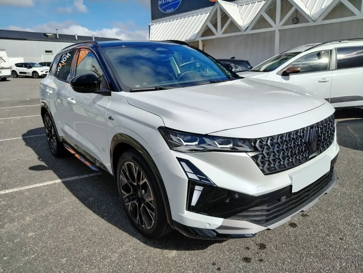 Renault Austral E-Tech blanc nacré avec toit noir, vue 3/4 avant mettant en valeur sa calandre et ses phares LED.