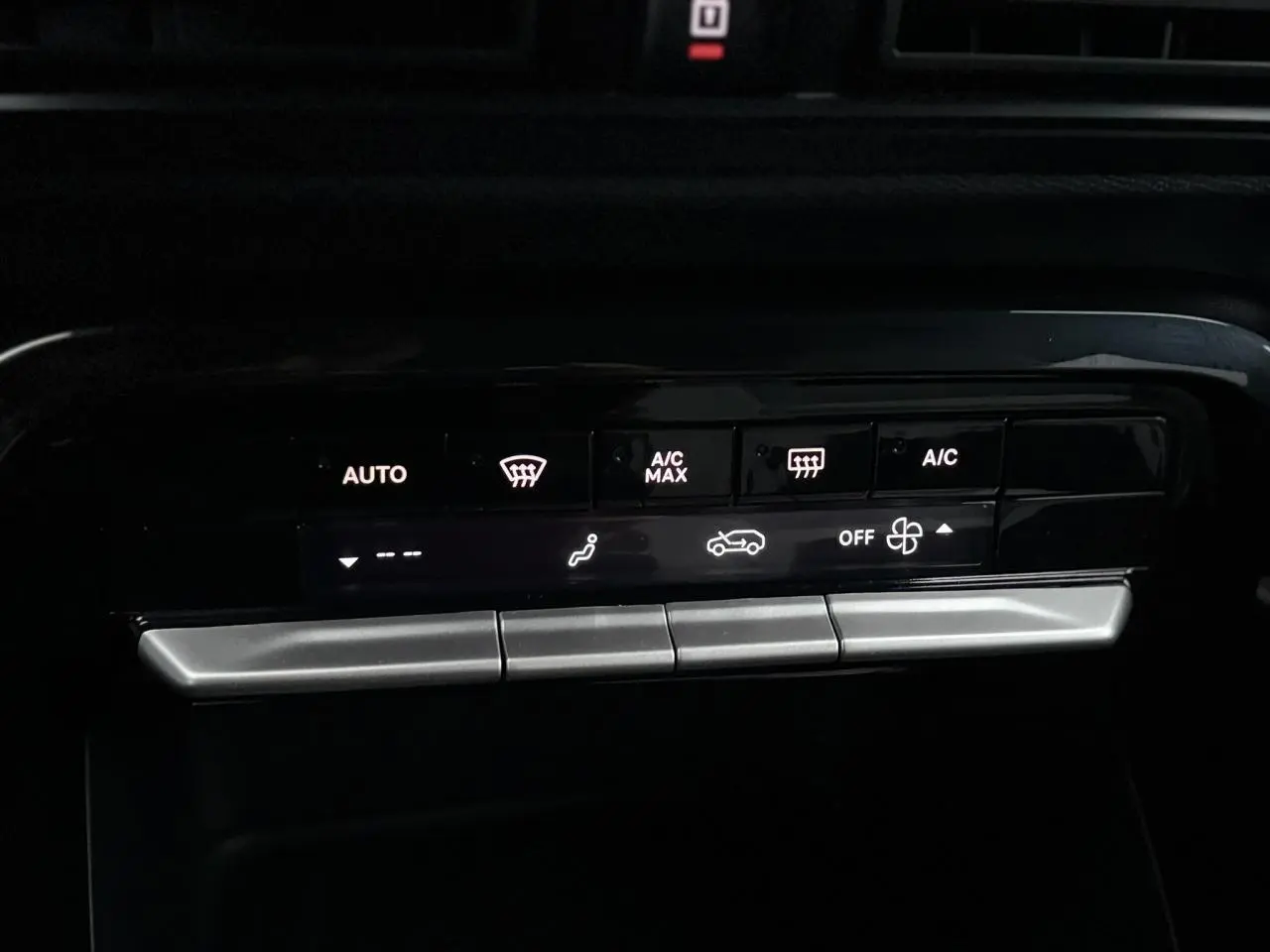 Gros plan sur les commandes de climatisation automatique de la Citroën C3 Turbo 100 Max, affichage LED blanc sur fond noir.
