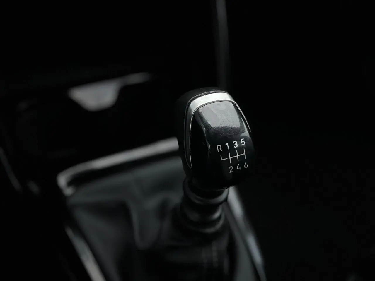 Gros plan sur le levier de vitesses manuel noir de la Citroën C3 Turbo 100 Max, intérieur sombre et épuré.