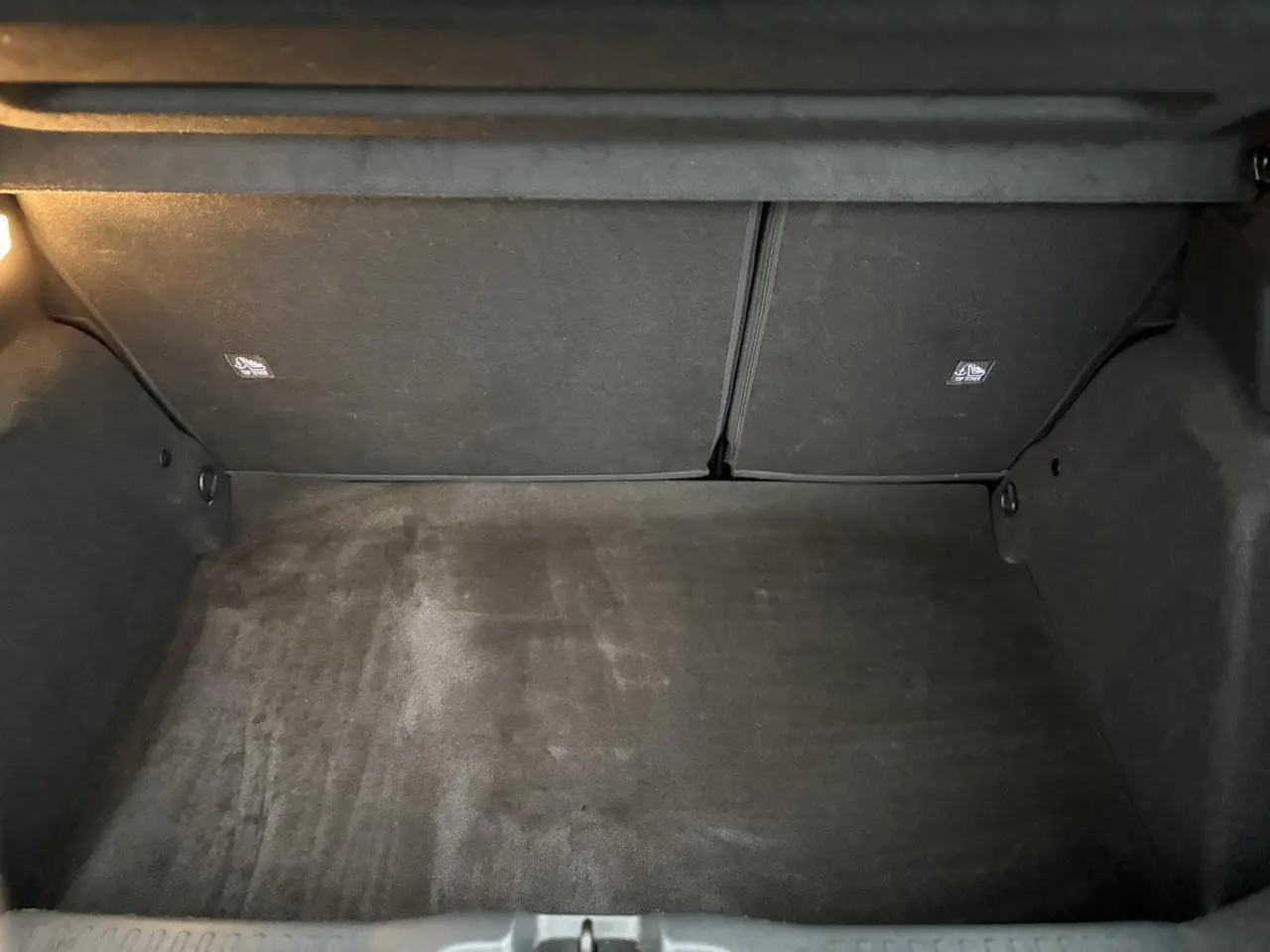 Coffre vide vu de face de la Citroën C3 Turbo 100 Max 2025, intérieur noir avec éclairage latéral.