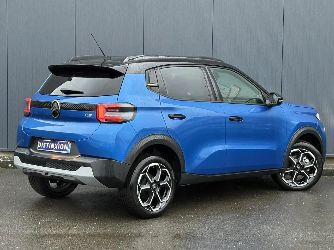 Vue 3/4 arrière droite d'une Citroën C3 2025 Bright Blue avec toit noir Perla et jantes alliage diamantées.