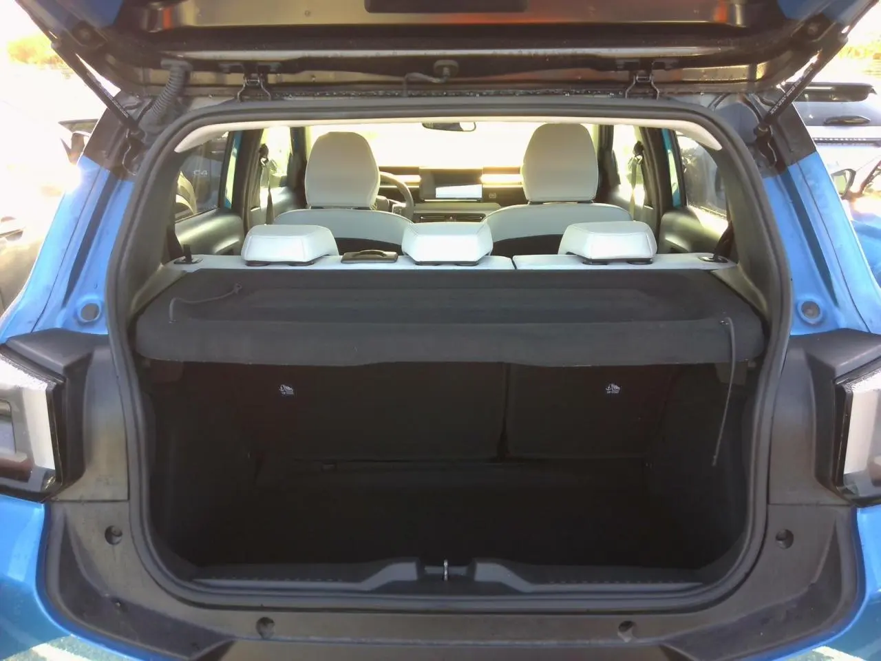 Coffre ouvert vu de l'arrière d'une Citroën C3 2025 Bright Blue avec intérieur clair et hayon relevé.