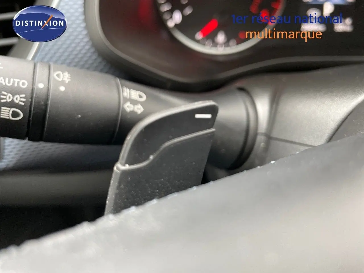 Détail de la commande au volant noir et levier de clignotant dans l’habitacle d’une Renault Arkana noire 2023.