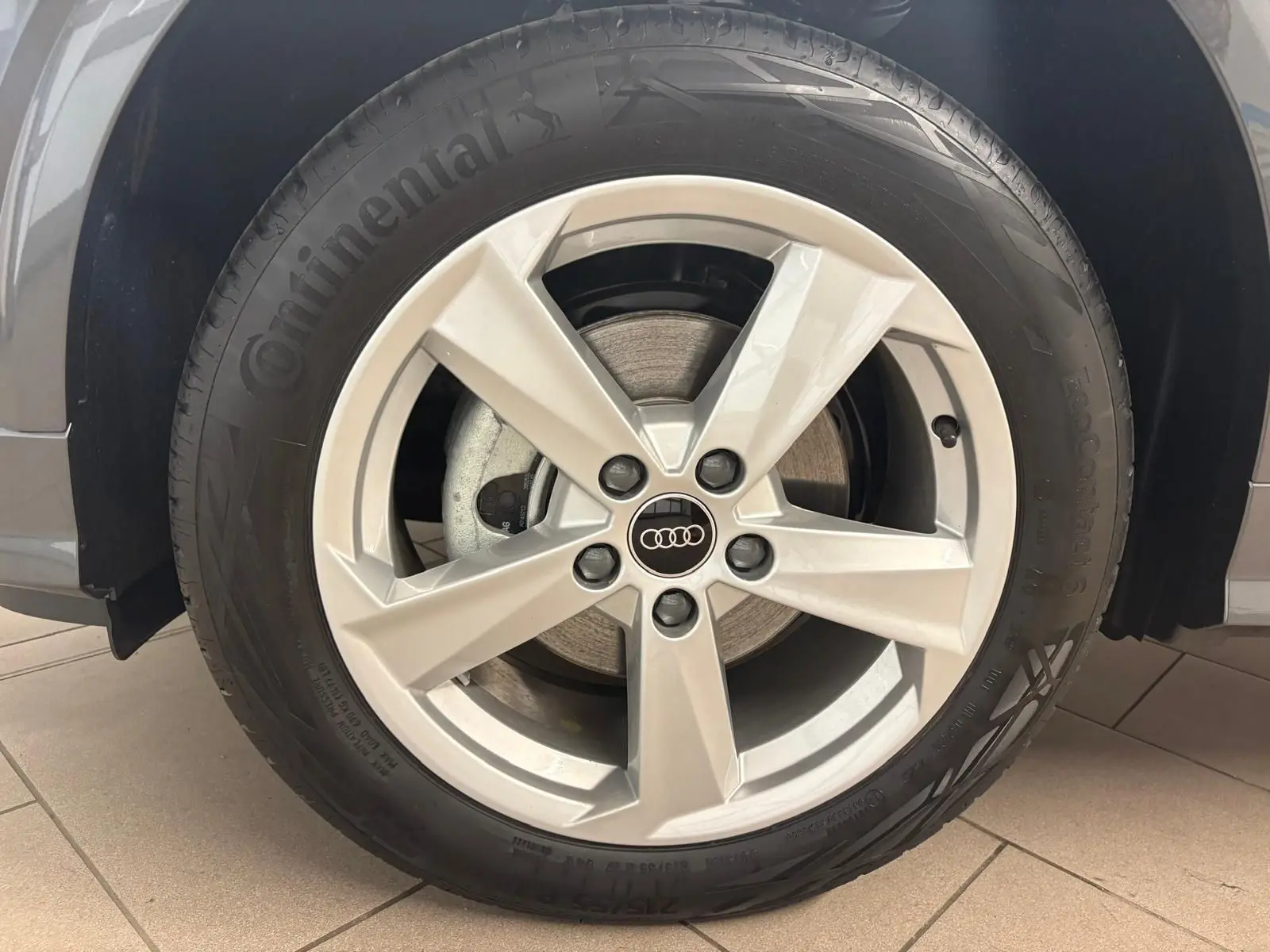 Gros plan sur la roue avant gauche de l'Audi Q2 35 TFSI S Line 2026 en gris Daytona avec jante alliage cinq branches.