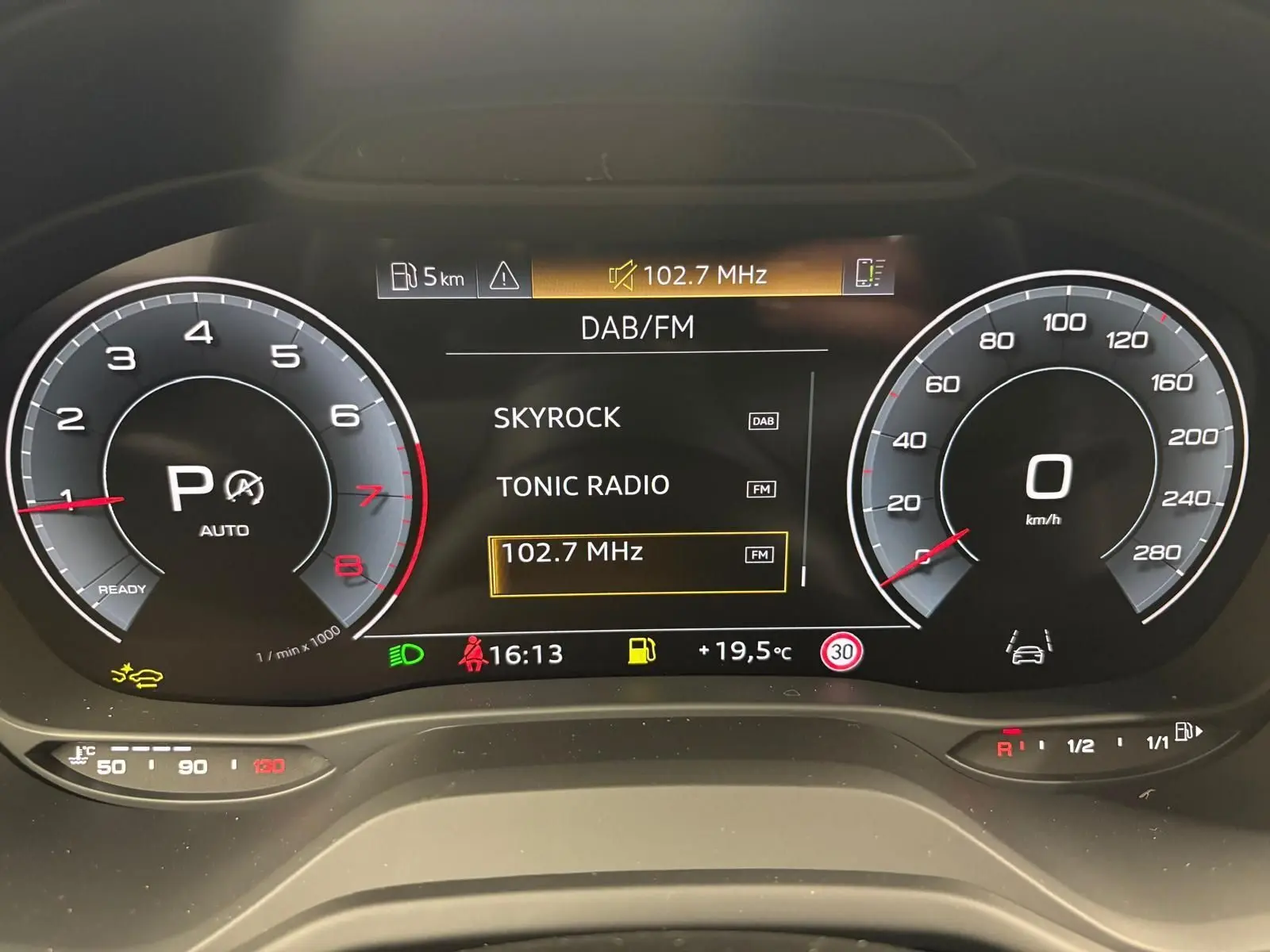 Tableau de bord numérique de l'Audi Q2 35 TFSI S Line 2026 affichant la radio DAB/FM et compteurs à zéro.