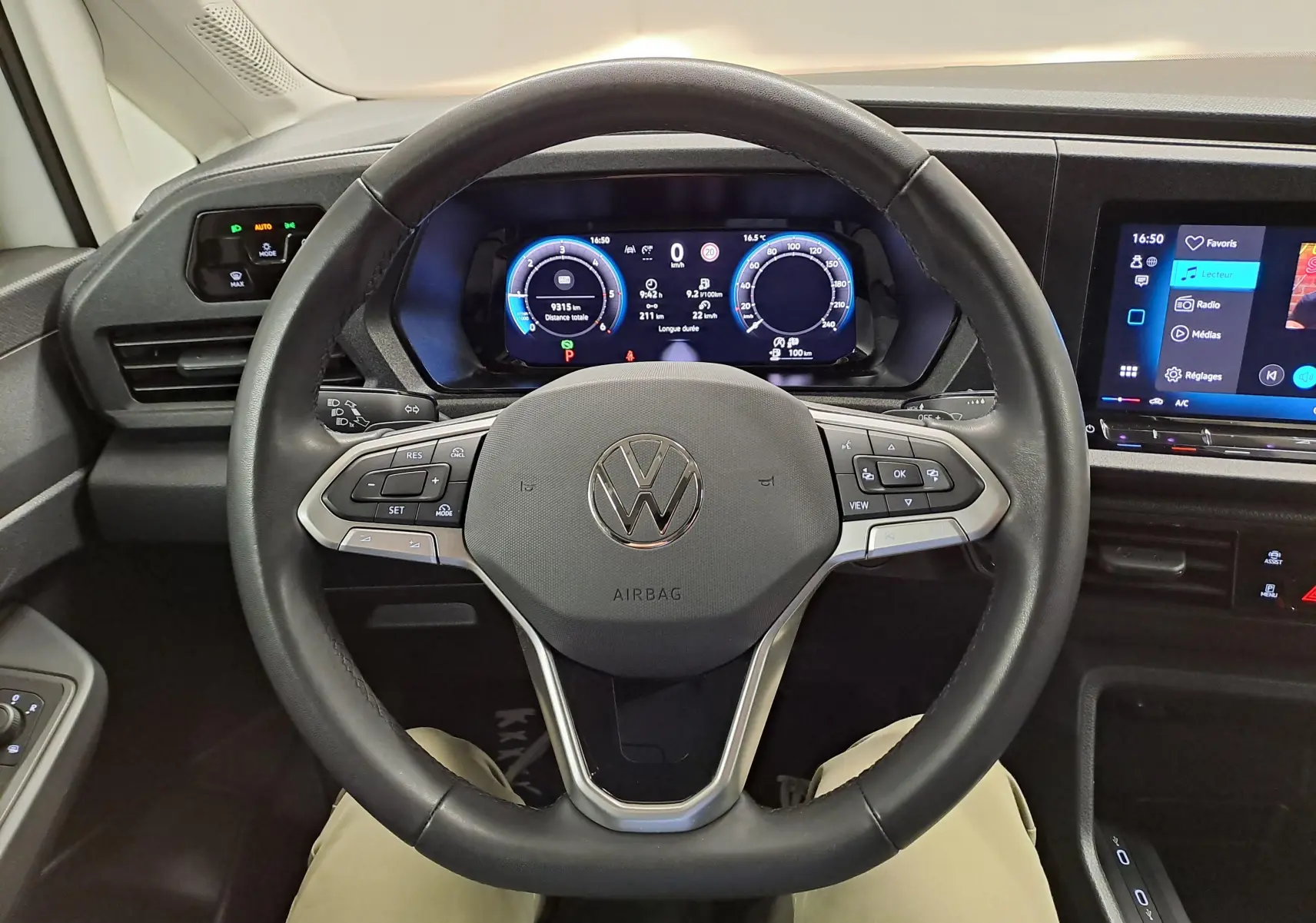 Vue intérieure centrée sur le volant cuir noir et le tableau de bord numérique du Volkswagen Caddy 2025.