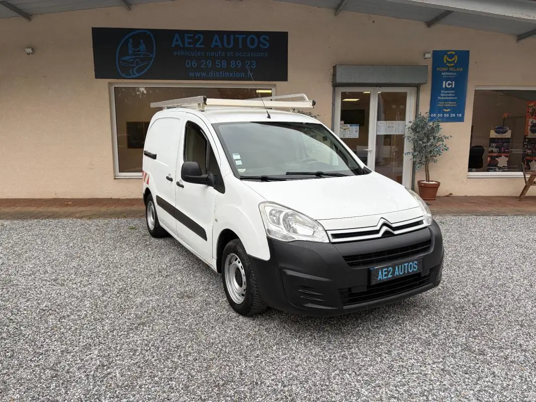 Citroën Berlingo Fourgon blanc vue 3/4 avant droit avec galerie de toit, stationné devant un garage AE2 Autos.