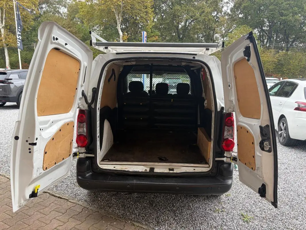 Vue arrière du Citroën Berlingo fourgon blanc 2018 avec portes ouvertes montrant l’espace de chargement vide et la cloison de séparation.