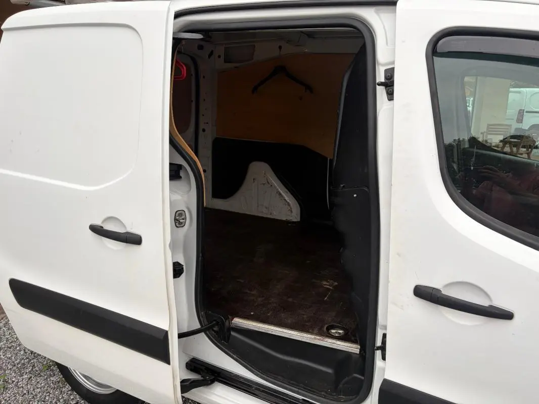 Vue latérale gauche du Citroën Berlingo blanc 2018 avec porte coulissante ouverte dévoilant l’espace de chargement vide.