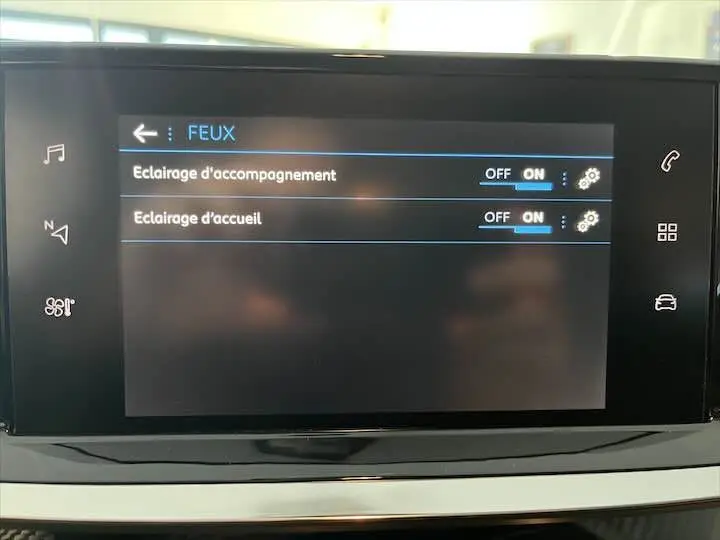 Écran tactile intérieur de la Peugeot 208 gris Artense, affichant les réglages d'éclairage d'accompagnement et d'accueil.