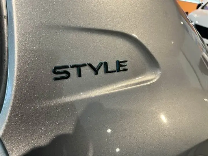 Gros plan sur l’inscription STYLE en relief sur la carrosserie gris Artense métallisé d’une Peugeot 208.