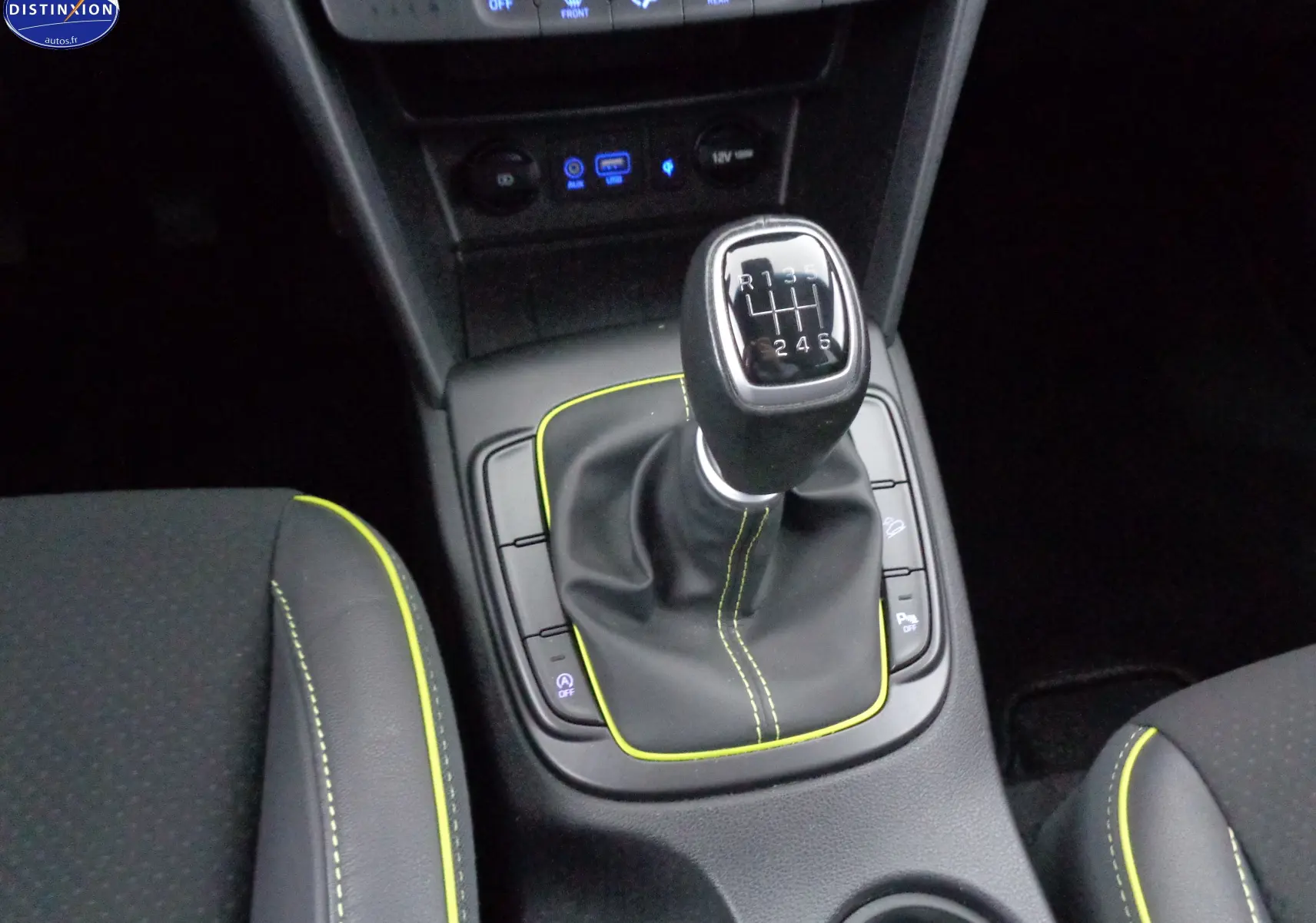 Vue rapprochée de la commande de boîte manuelle noire avec surpiqûres jaunes du Hyundai Kona 2019 Acid Yellow.