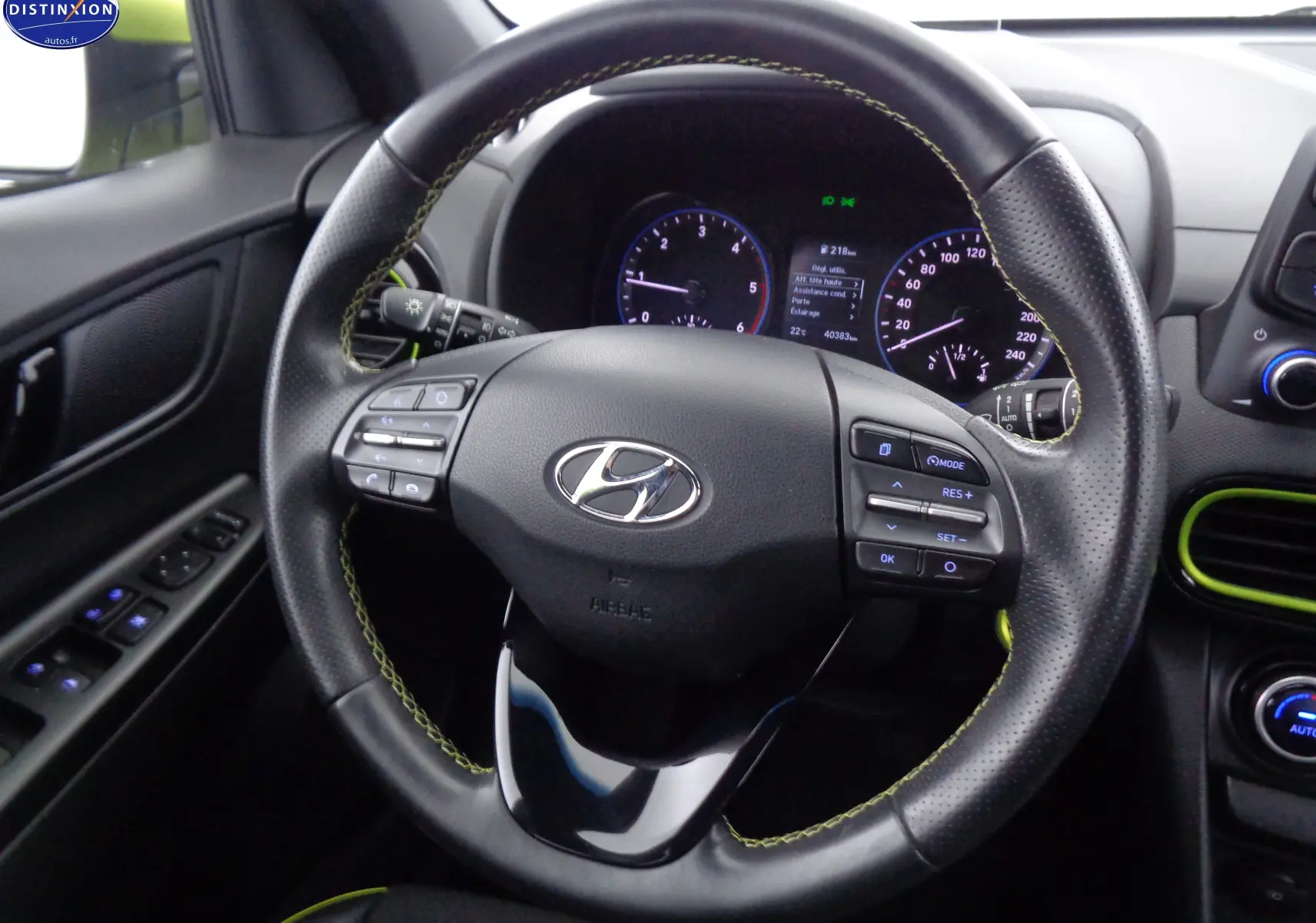 Vue rapprochée du volant en cuir noir avec surpiqûres jaunes du Hyundai Kona 2019, tableau de bord et détails intérieurs visibles.