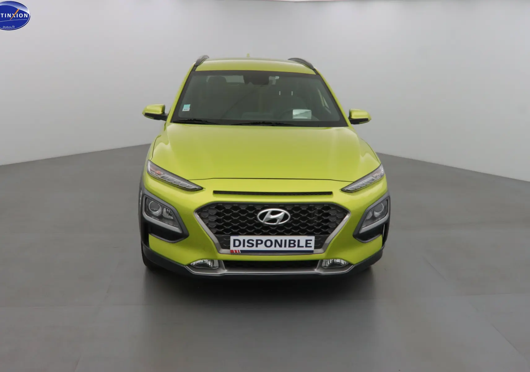 Vue frontale d'un Hyundai Kona 2019 en jaune acidulé avec calandre noire et phares LED distinctifs.