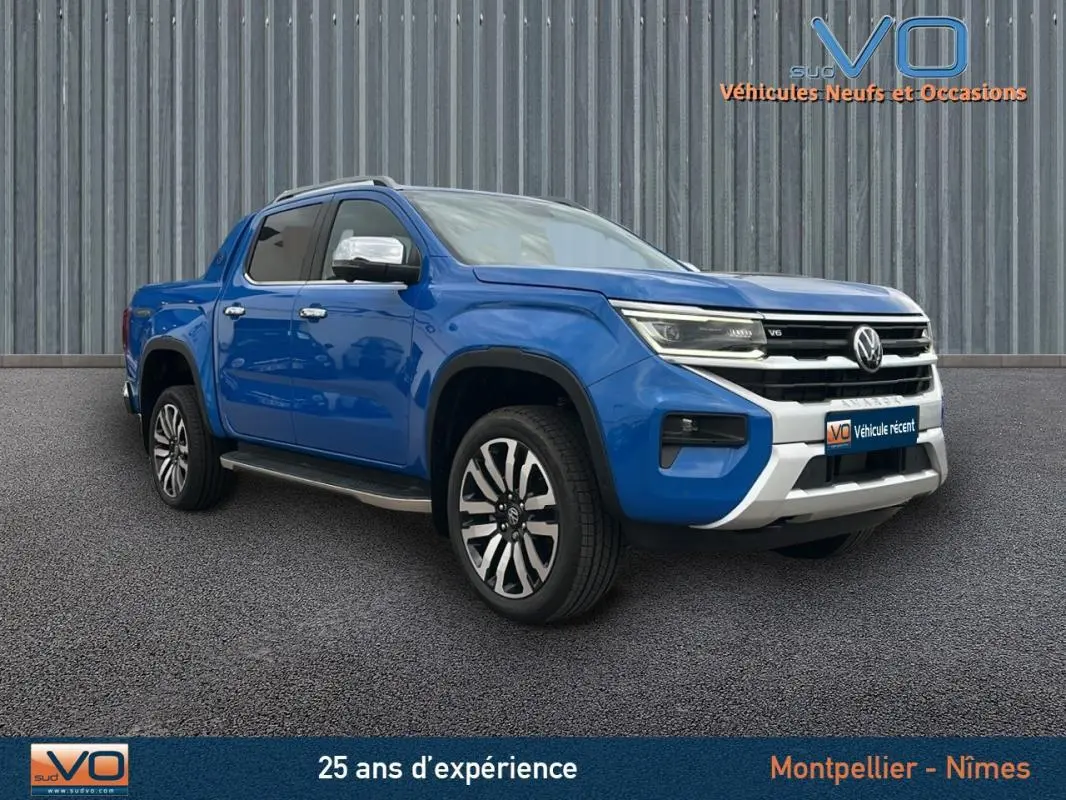 Volkswagen Amarok Aventura bleu en 3/4 avant droit avec jantes alliage 21 pouces et marchepieds visibles.