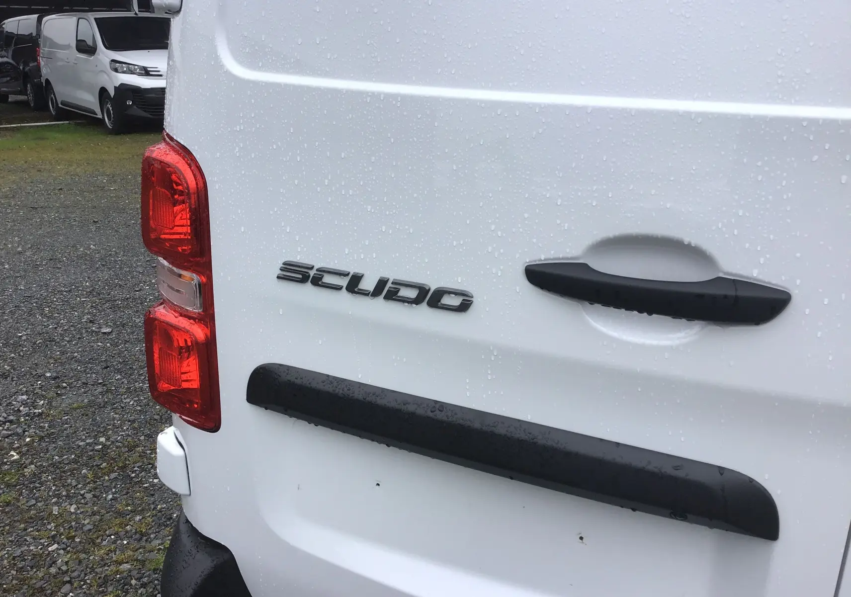 Gros plan sur l'arrière blanc du FIAT Scudo Fourgon 2024, mettant en valeur la poignée noire et le logo "SCUDO".