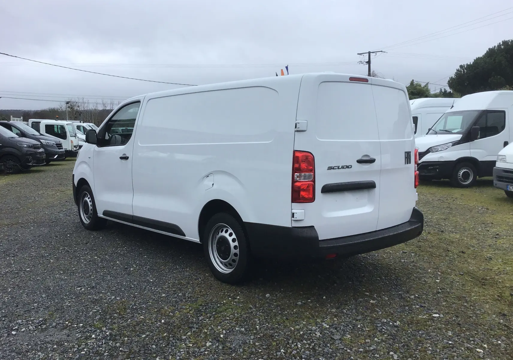 Vue 3/4 arrière droite d’un FIAT Scudo Fourgon blanc 2024 avec porte latérale coulissante et pare-chocs noir.