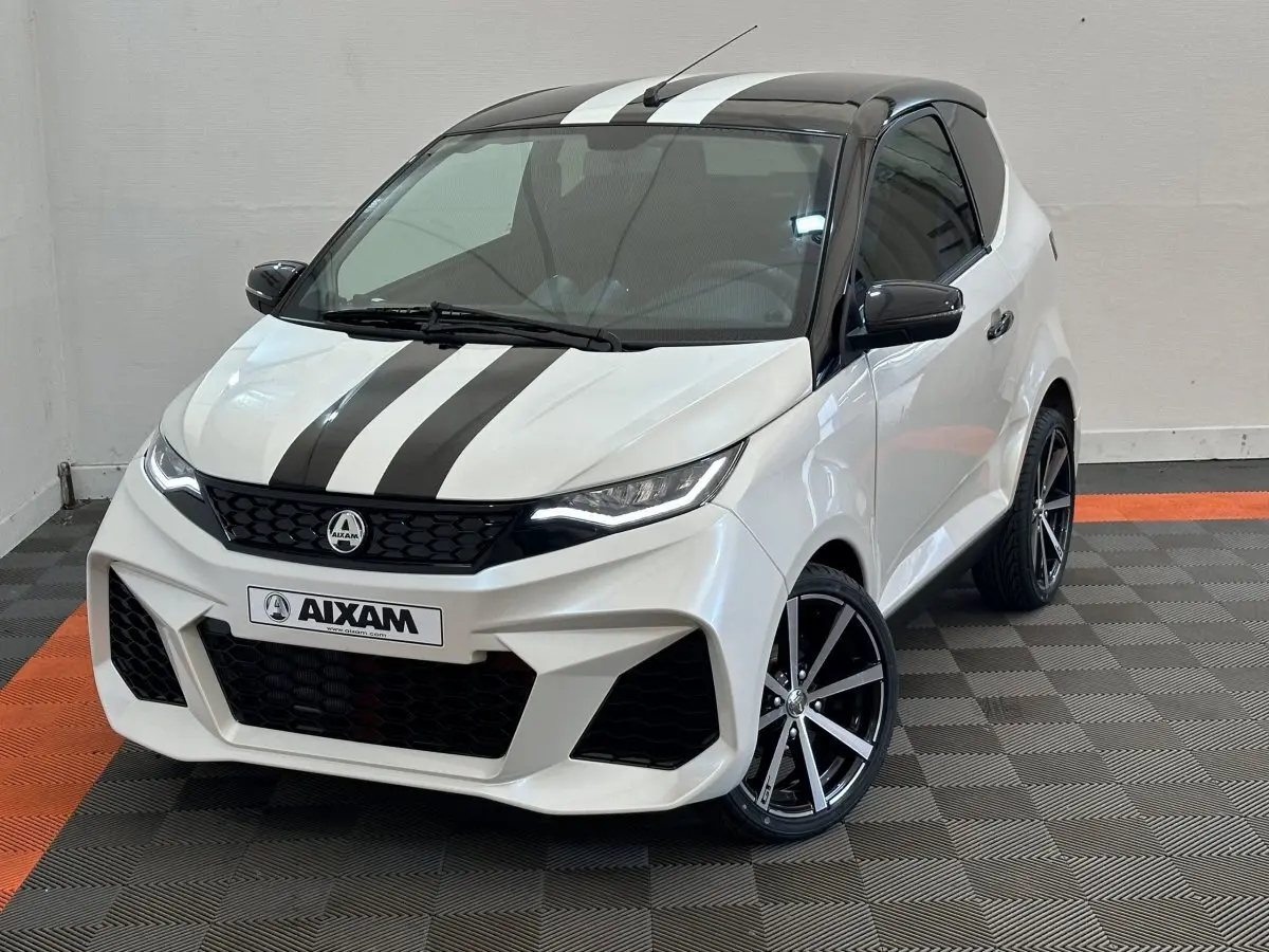 Vue 3/4 avant droite d'une Aixam Ambition 0.5 City GTO blanche avec bandes noires et jantes noires à rayures argentées.