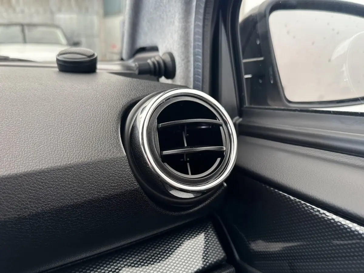 Détail de la sortie d’air ronde chromée côté conducteur dans l’habitacle de l’AIXAM AMBITION 0.5 CITY GTO blanc.