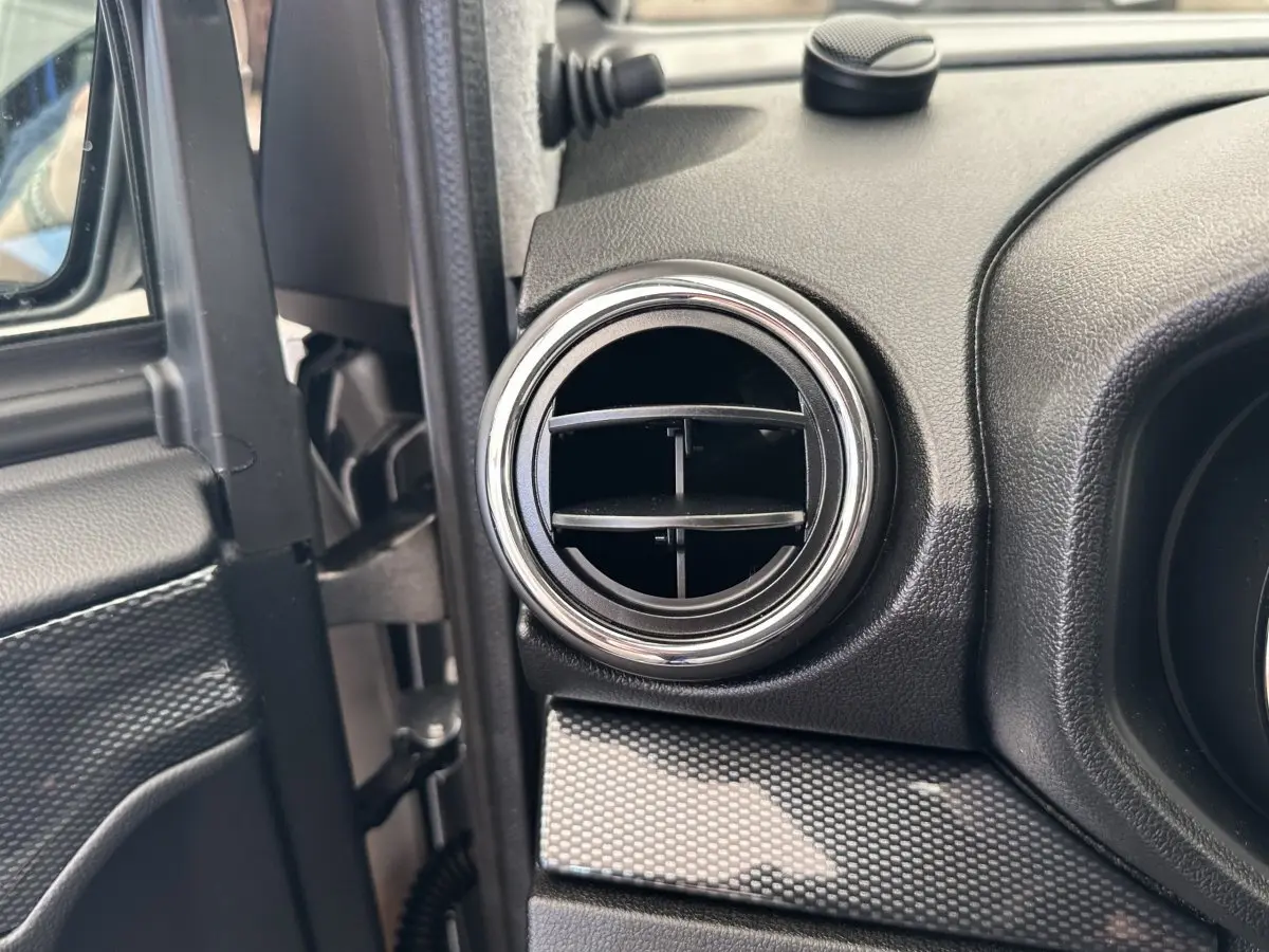 Détail de la sortie d’air ronde côté conducteur de l’habitacle de l’AIXAM AMBITION 0.5 CITY GTO blanc 2026.