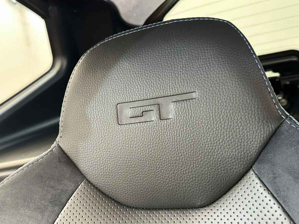 Gros plan sur l’appuie-tête noir embossé GT de l’AIXAM AMBITION 0.5 CITY GTO 2026, intérieur cuir et alcantara.