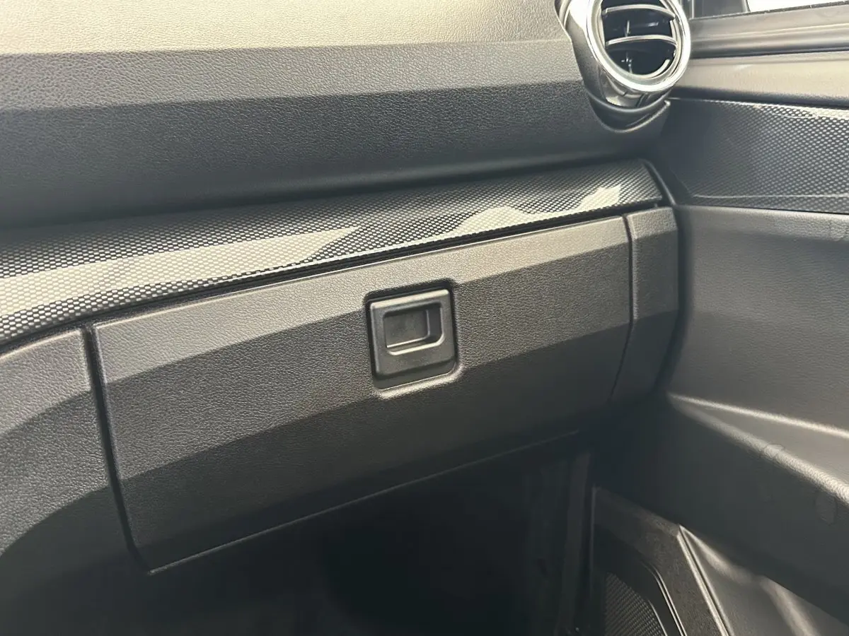 Détail de la boîte à gants et partie droite du tableau de bord noir de l'AIXAM AMBITION 0.5 CITY GTO 2026.